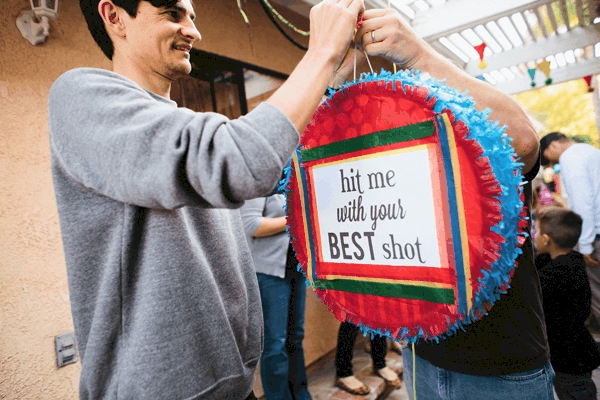 Man holding a pinata that says "hit me with your best shot."