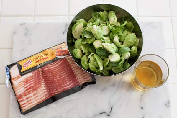 Ingredients to make braised brussels sprouts with bacon on a counter.