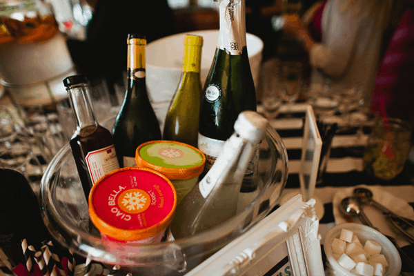 A beverage bucket holding a variety of bottles and frozen sorbet.