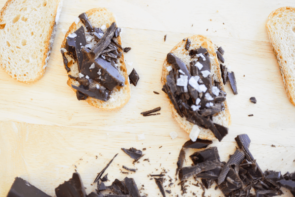 Toasted baguette slices topped with dark chocolate and sea salt.