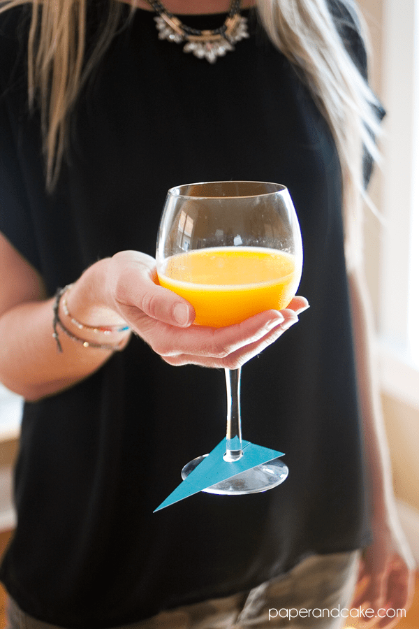 Woman holding a mimosa in a wine glass.