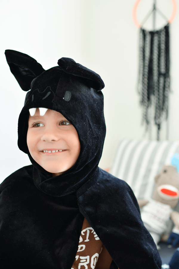 Kid in bat halloween costume.