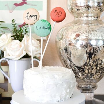 A cake with a DIY cake topper made from macarons with edible ink.