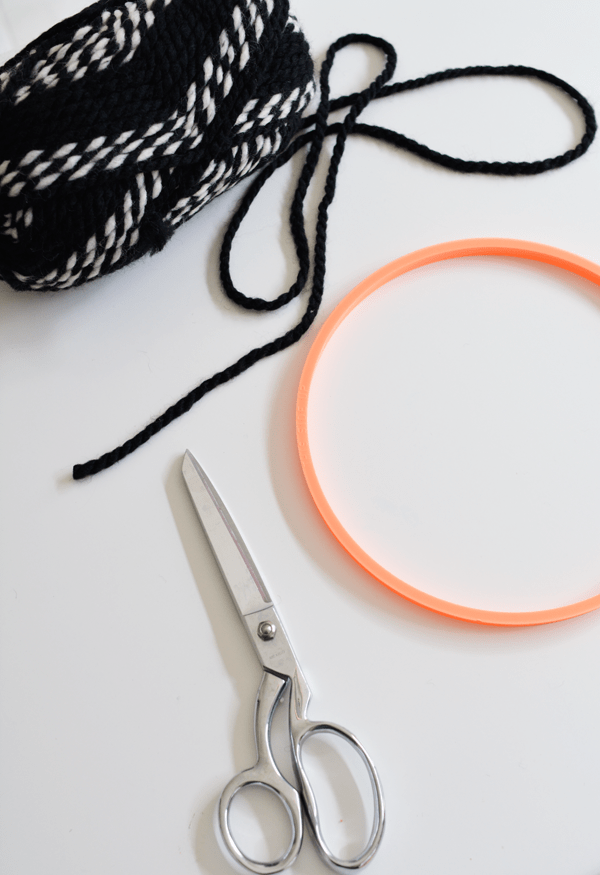 Yarn, scissors and an embroidery hoop to make a diy yarn wall hanging.