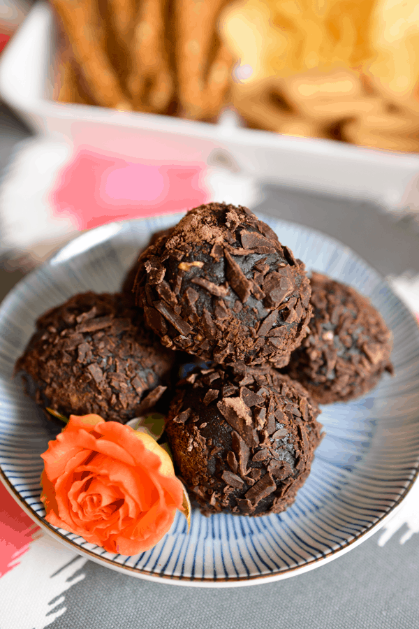 Dessert cookie balls stacked up on a small plate. 