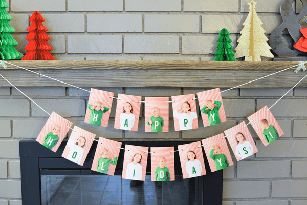 DIY holiday garland made with kids' photos hung from a mantle.