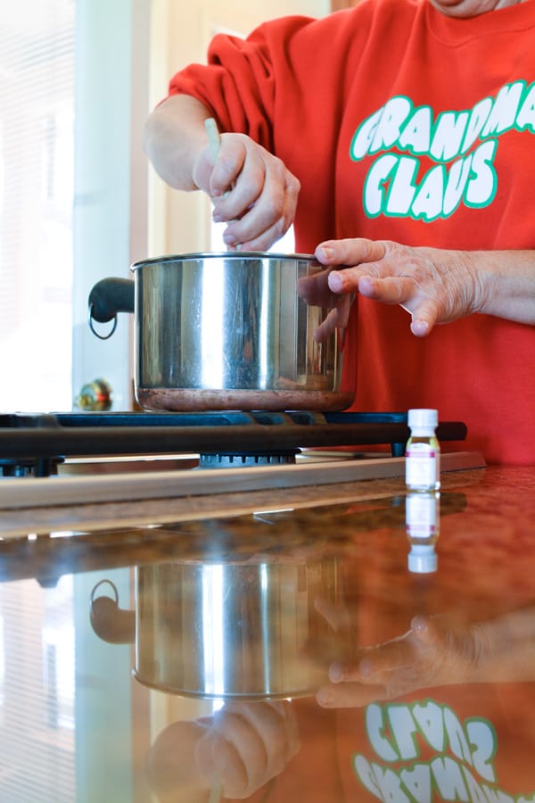 Woman stirring a saucepan on the stovetop.