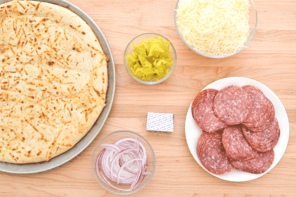Overhead shot of ingredients needed to make a Salami Pizza.