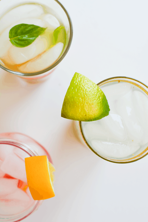 Overhead shot of fruit-infused waters garnished with pieces of citrus.