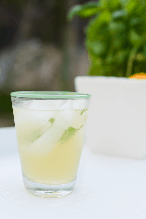 A Meyer Lemon and Basil Gin Cocktail in a glass on a table.