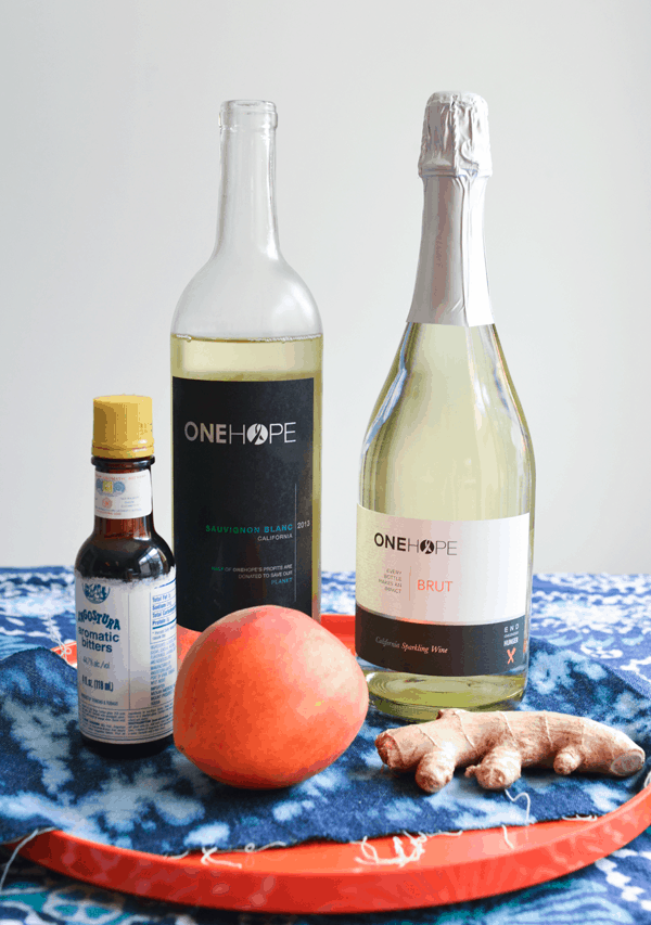 Ingredients to make a Ginger Peach Wine Cocktail including ginger, peaches, wine and bitters.