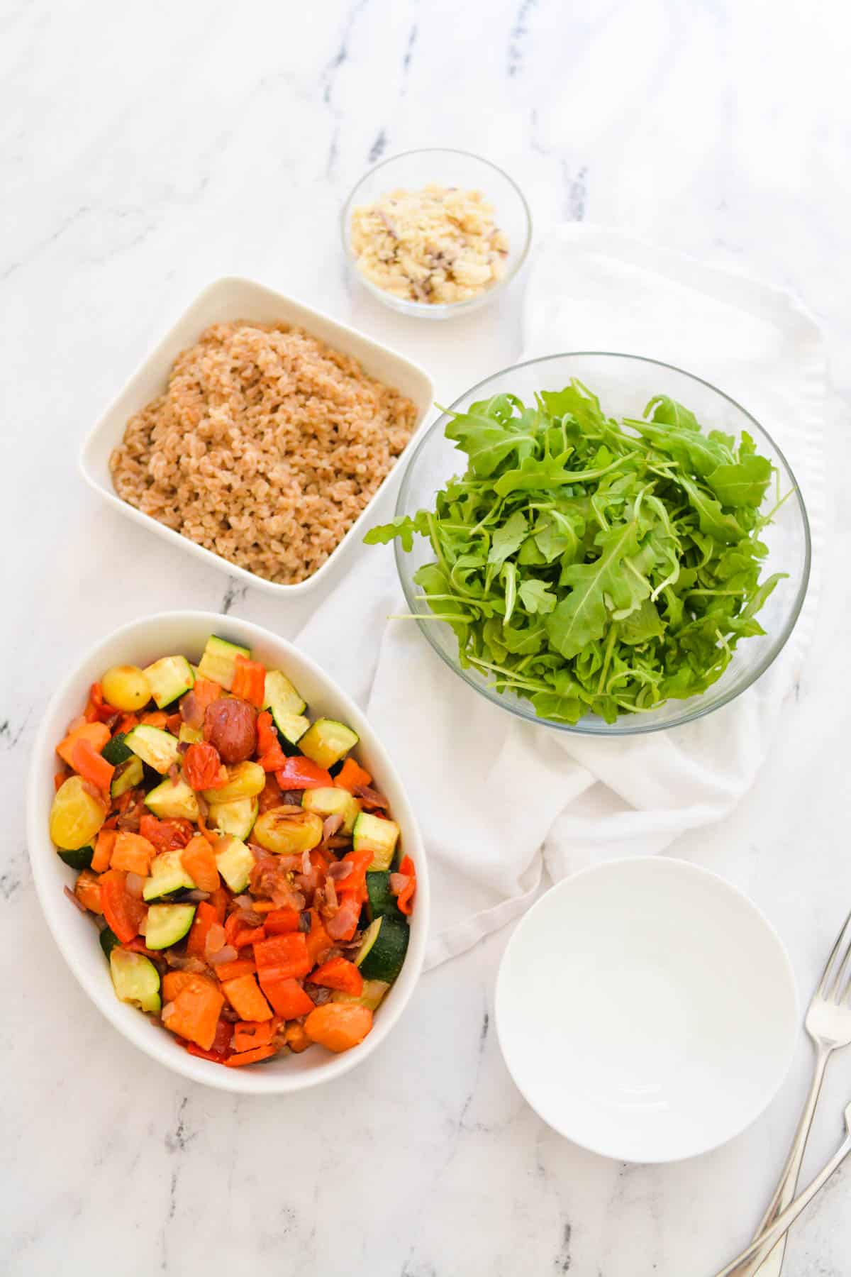 Overhead shot of all the components of a roasted veggie farro bowl.