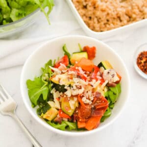 Overhead shot of a bowl of arugula farro salad with roasted vegetables.