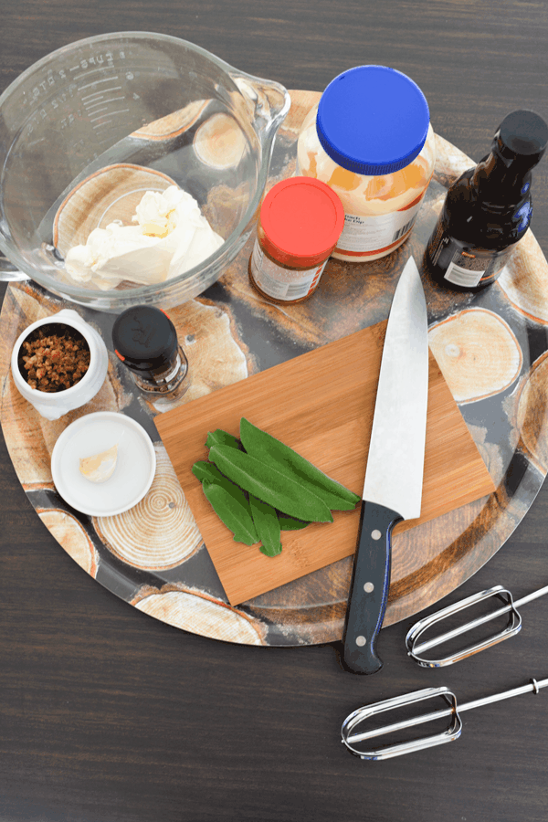 Ingredients for a cold bacon dip on a tray with a small cutting board.