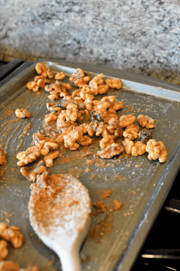 Cinnamon Sugar Walnuts spread out to cool on a cookie sheet.