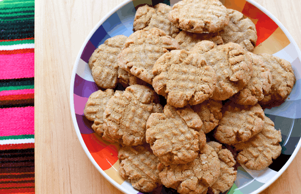 Colorful plate of sunbutter cookies on a wood tray.