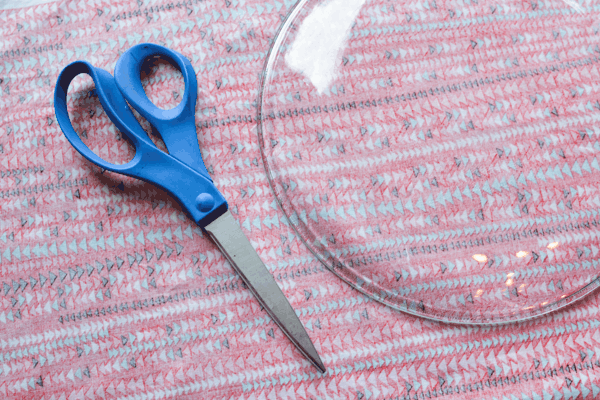 Cutting fabric to fit the plate.