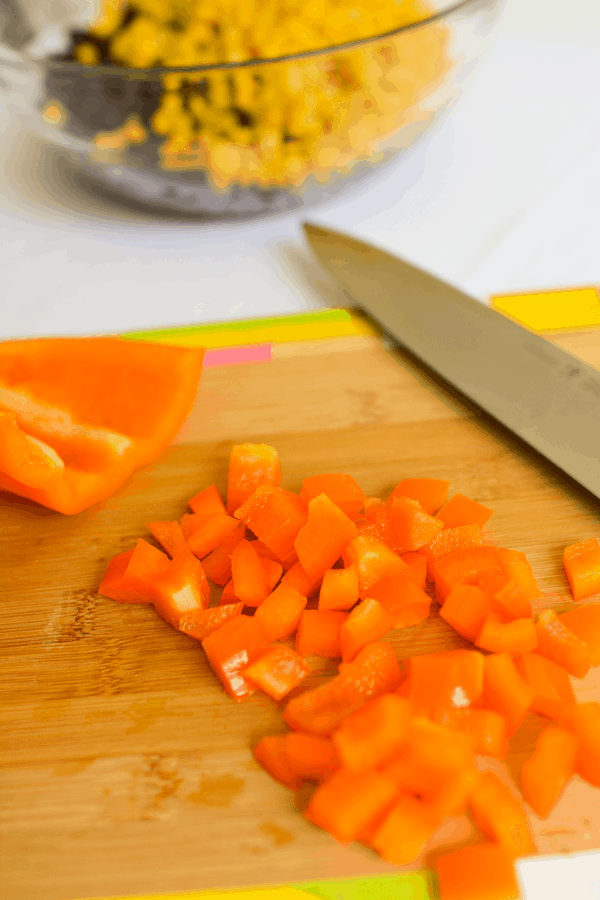 Chopped orange bell pepper on a cutting board.