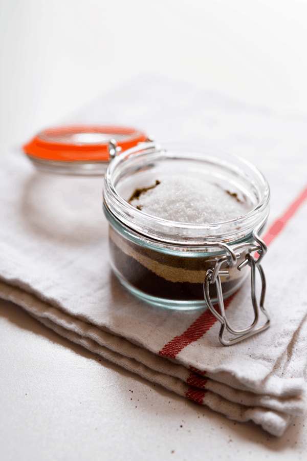 Glass canister with seasonings layered inside. 