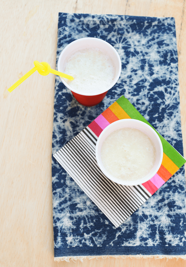 Fizzy pina colada slush mocktail pictured in red solo cups from overhead.