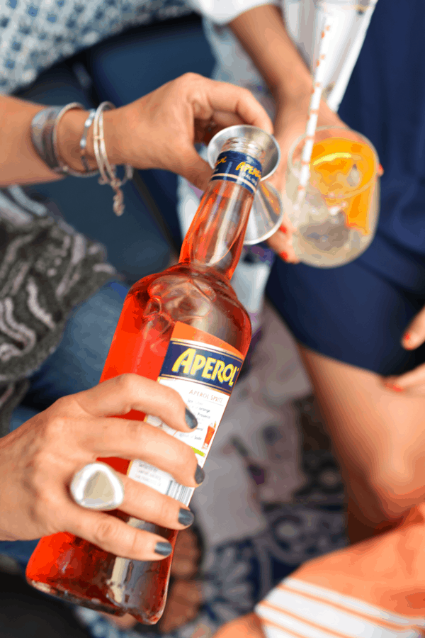 girl pouring Aperol into a jigger.