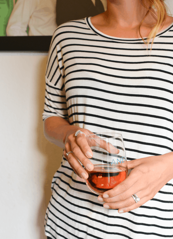 Woman in black and white striped shirt holding a glass of rose.