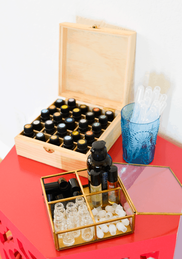 Essential oils on a table with supplies to make your own rollerball blends. 