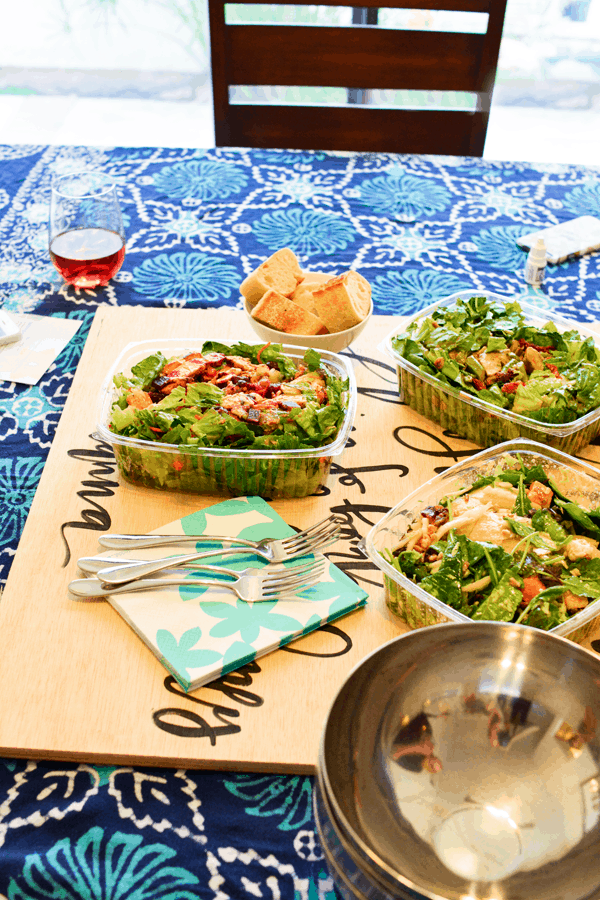 A table with salads from a restaurant in to-go containers. 