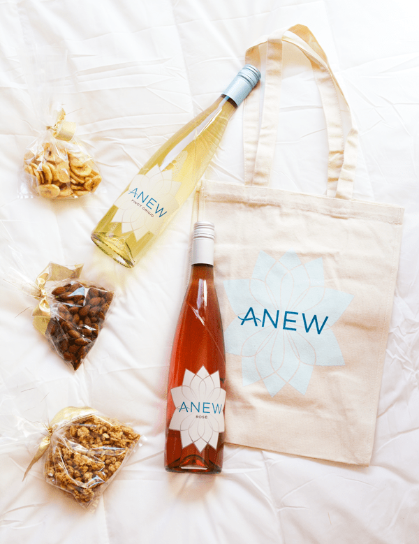 A shot of a canvas bag with a bottle of wine and some goodies sent home in a goodie bag for a party. 