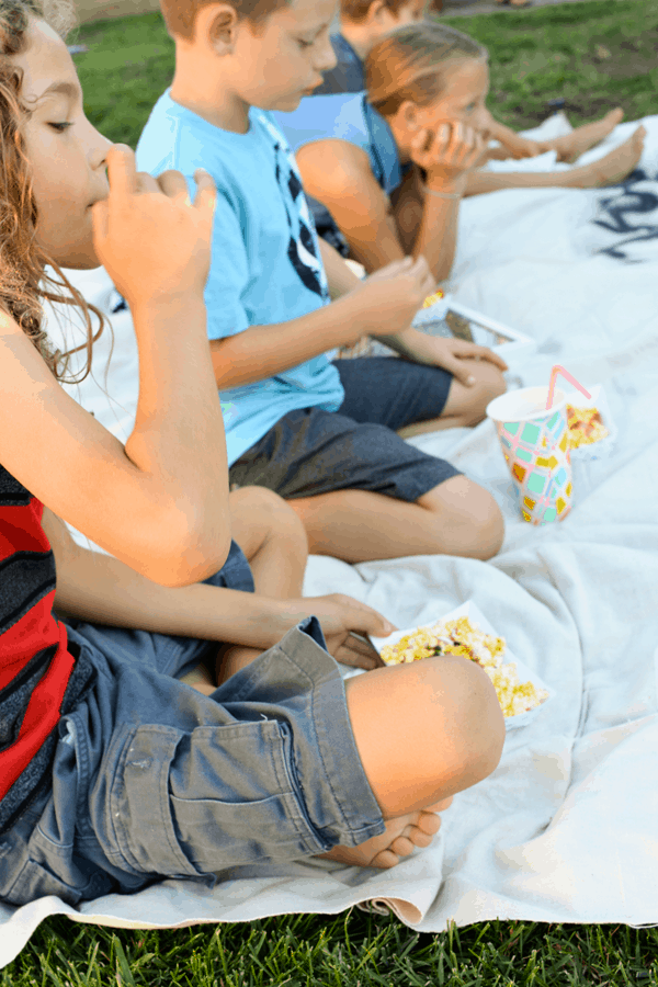 Kids eating snacks in the backyard. 