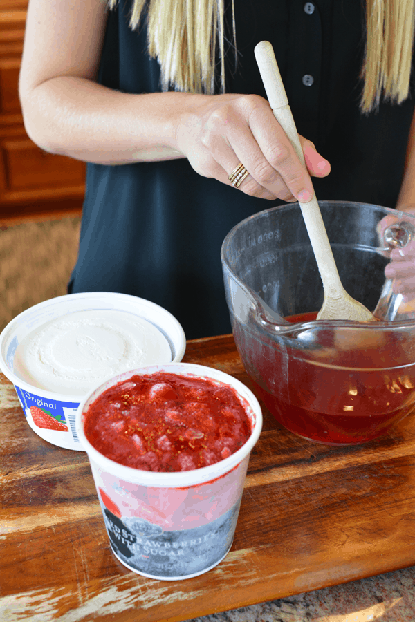 Stirring strawberry jello for a Cool Whip Angel Food cake dessert.
