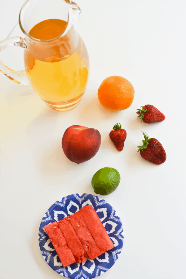 Pitcher of juice next to fresh fruit to make a kids sangria.