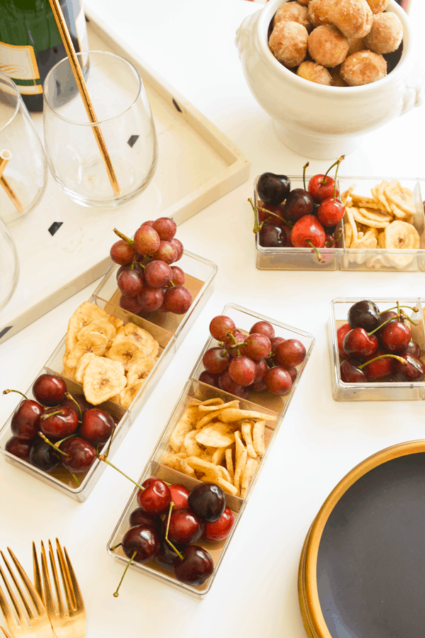 Small containers filled with fresh and dried fruits for people to snack on.