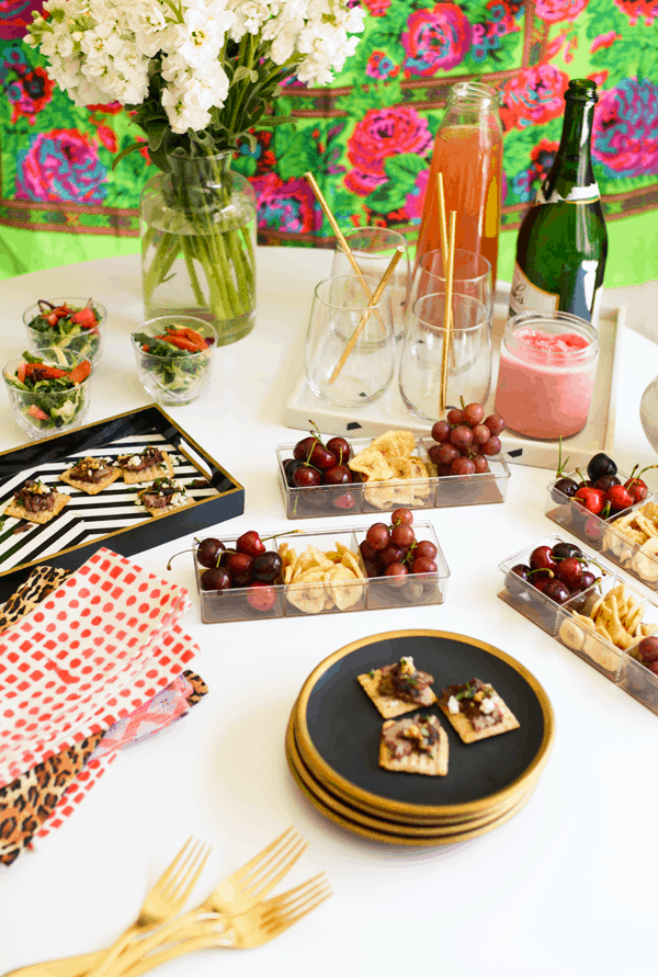 A table top filled with snacks, appetizers and drinks for a girls night in at home.