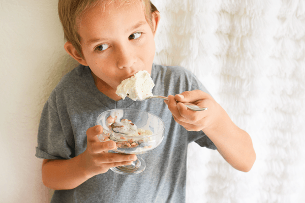 Child eating a bowl of ice cream and roasted figs.