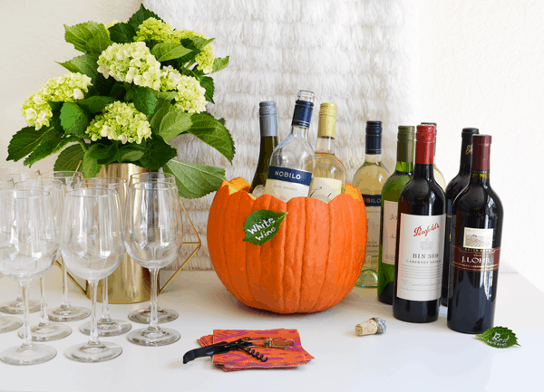 Friendsgiving ideas to keep your party stress free like using a pumpkin for an ice bucket.