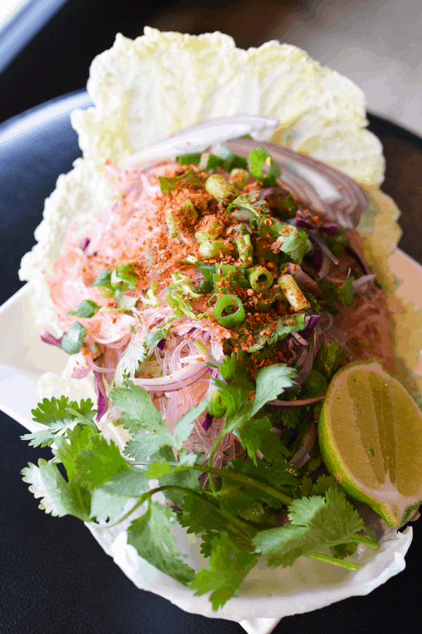 Glass Noodle Salad Recipe with citrus and spice on a white plate. 