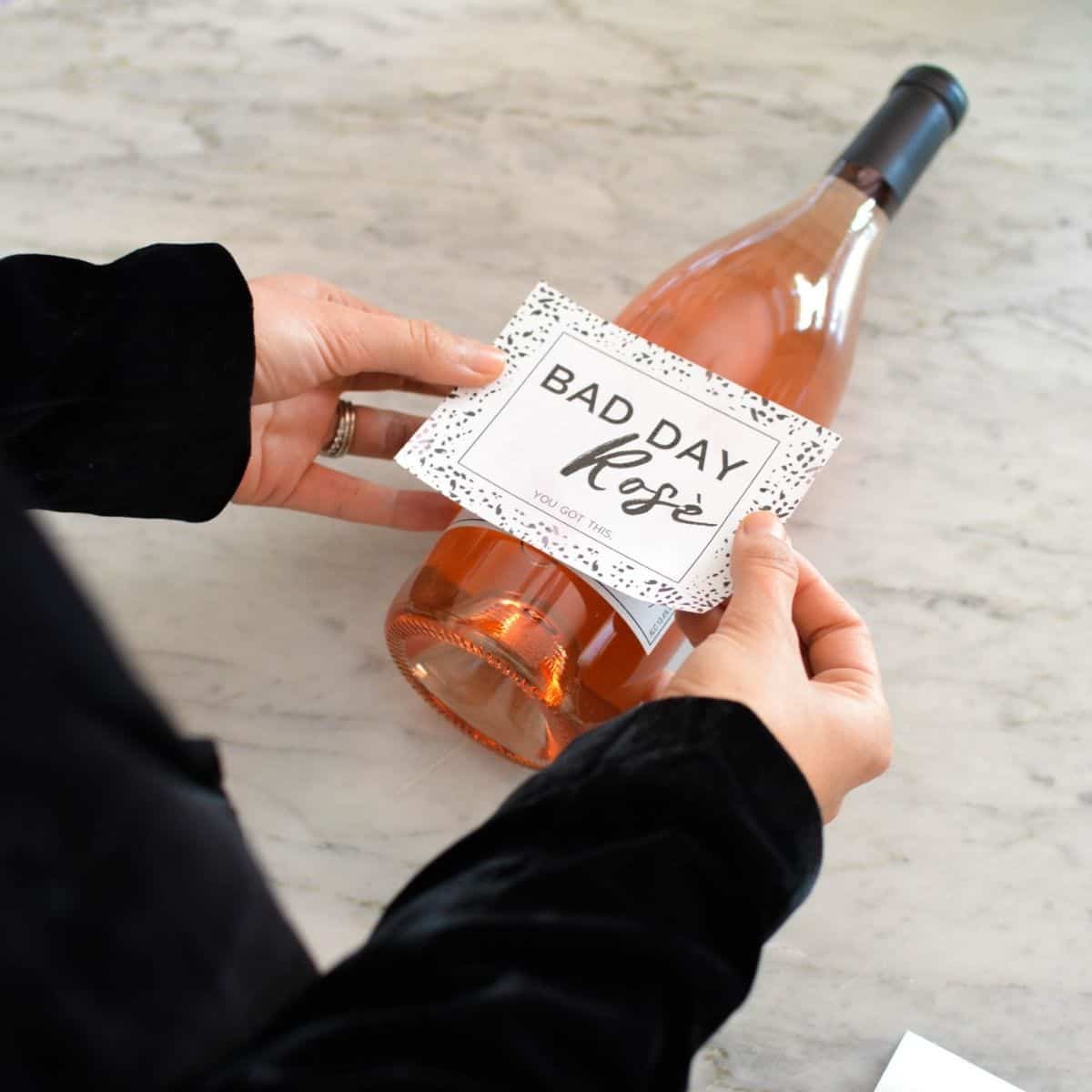 Woman placing a label on a bottle of rose