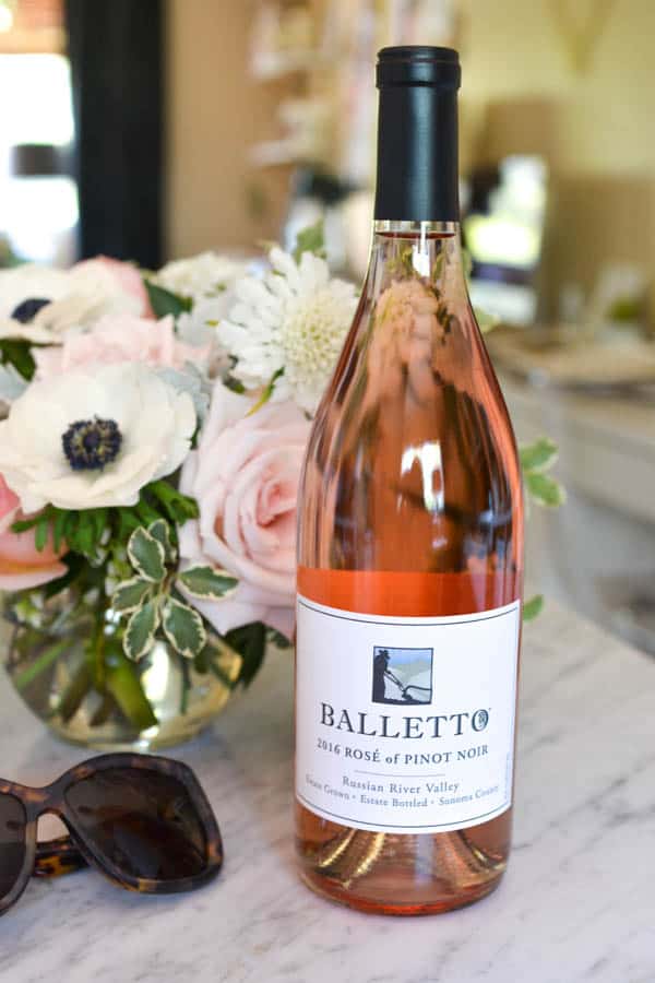 A bottle of Balletto Rosé on a table next to flowers and sunglasses. 