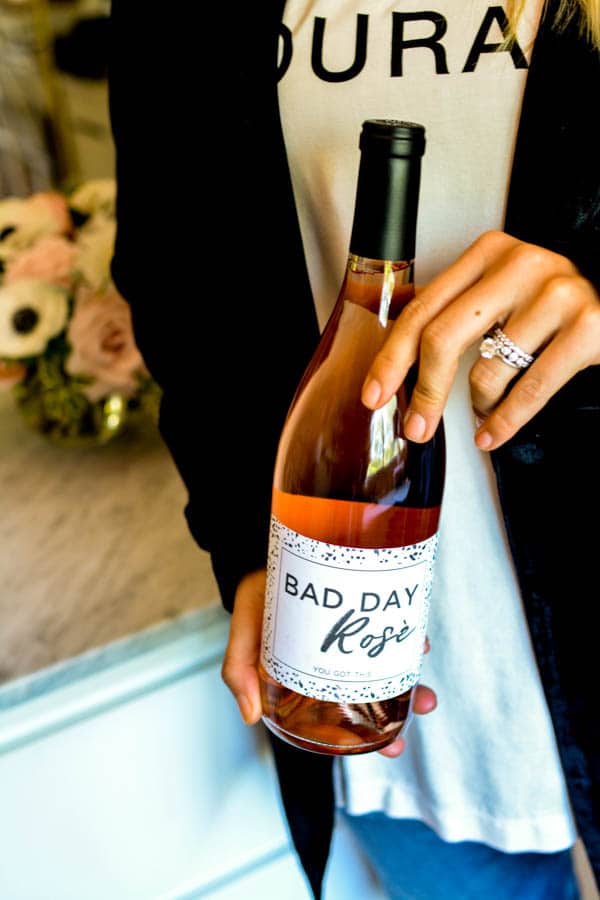 Woman holding a bottle of rose with a label that says "Bad Day Rosé".