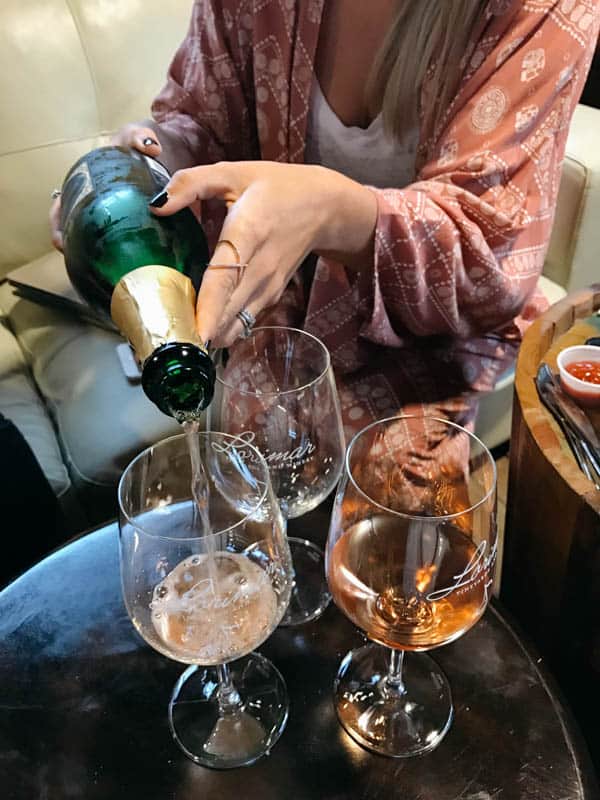 Woman pouring sparkling wine at Lorimar Winery in Temecula. 