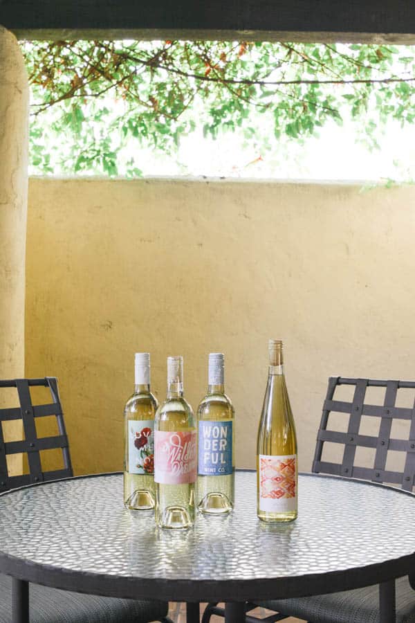 4 bottles of wine on a patio table. 