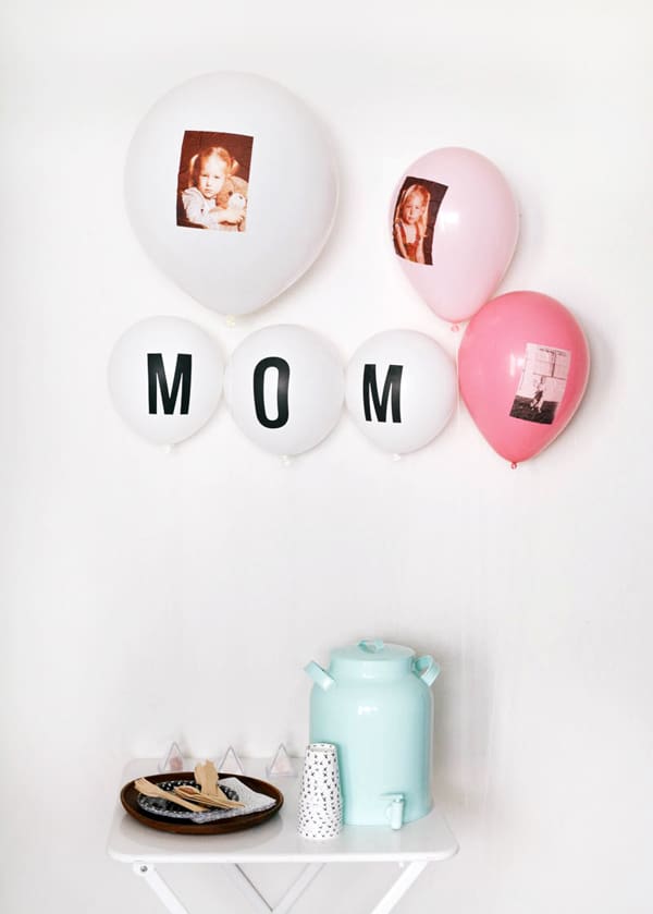 Balloons with photos on them for a party decoration behind a small table. 