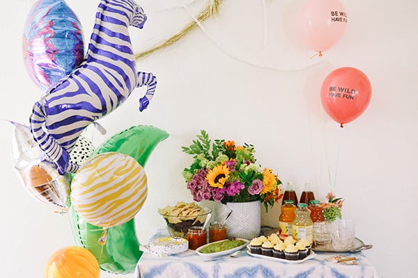 Balloon bouquet next to a food and drink table for a graduation party.