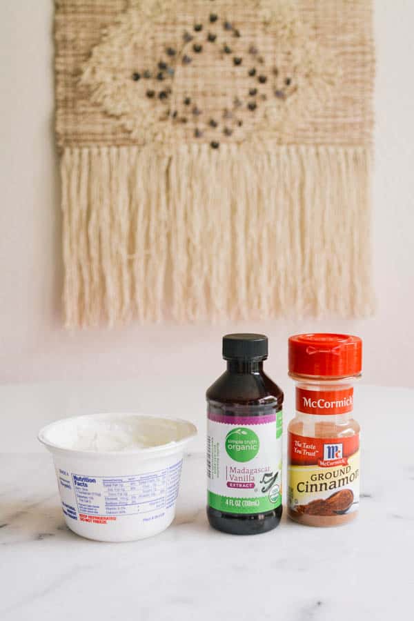 Yogurt pot, vanilla and cinnamon on the kitchen counter.