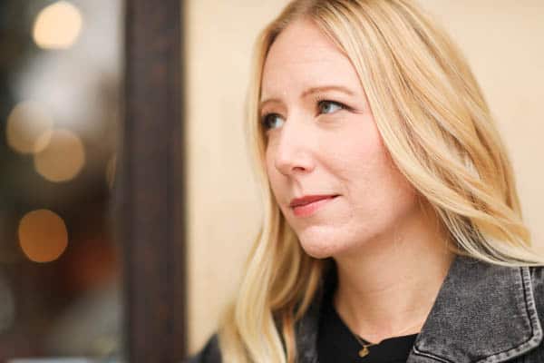 A woman's face with some acne scarring and uneven texture around her chin. 