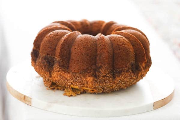 Bundt cake on a round marble platter on a table.