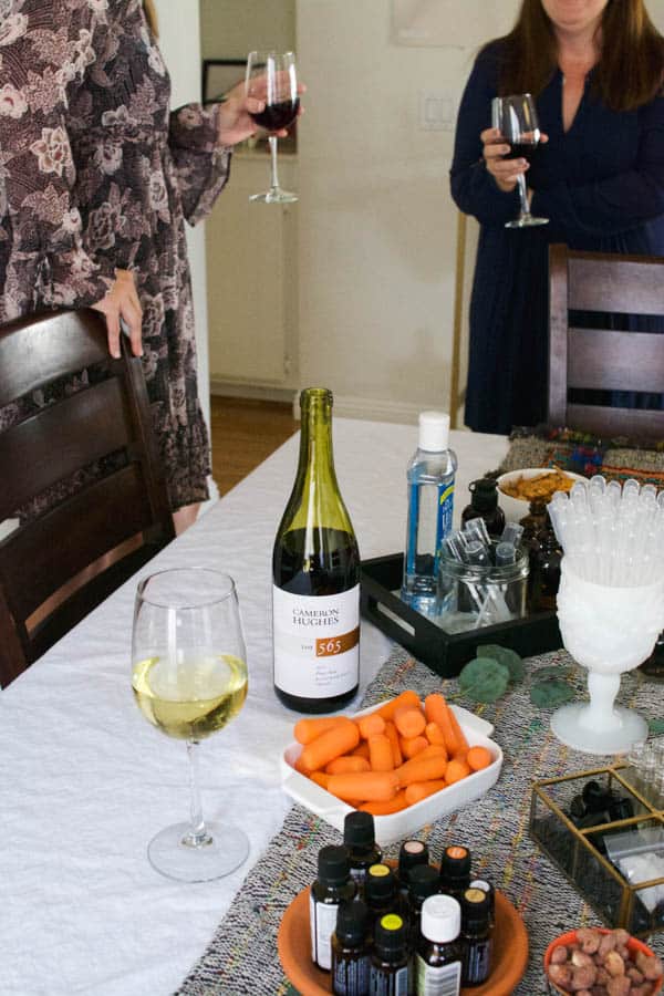 Friends standing around a table holding wine glasses. 