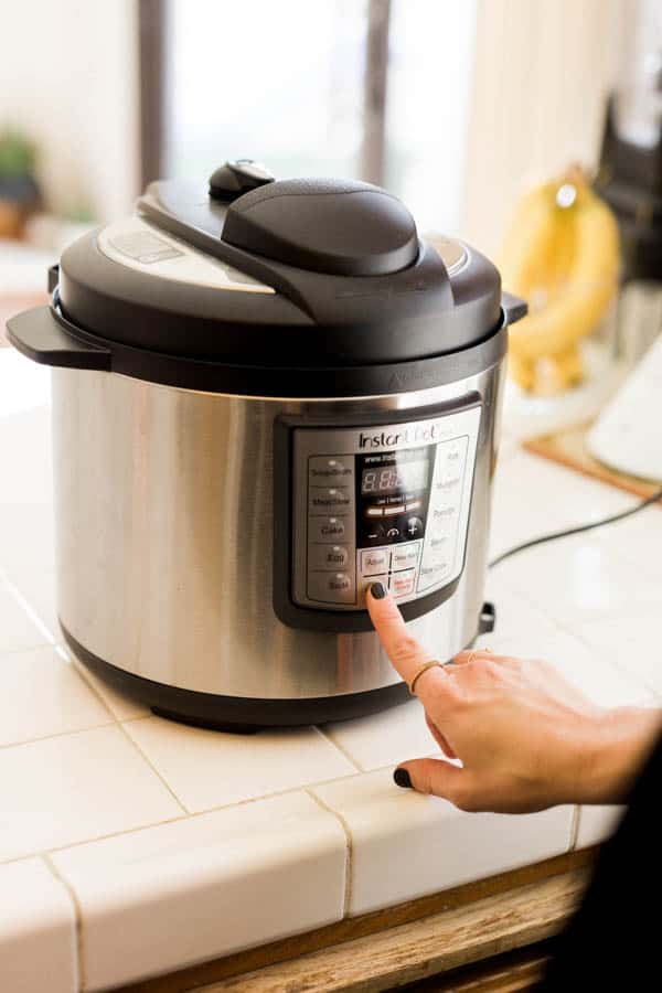 Woman pressing buttons on an Instant Pot.