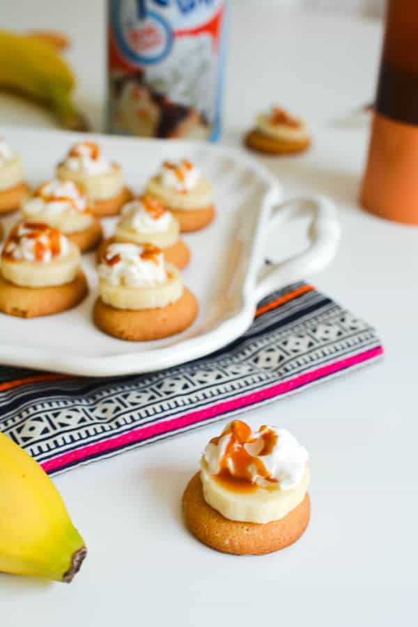 Close Up of a Nilla Wafer with a banana slice, whipped cream and a drizzle of caramel.